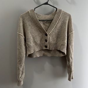 Long sleeve, cropped knit sweater with button up front.